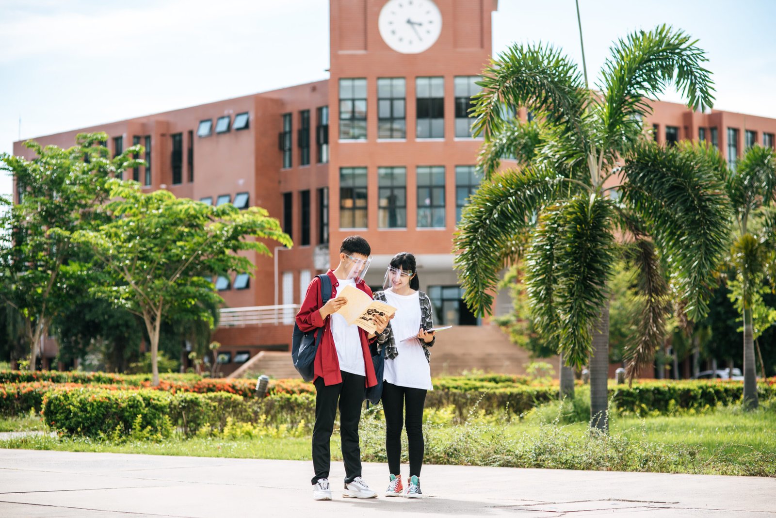 male and female students wear a face chill and stand in front of